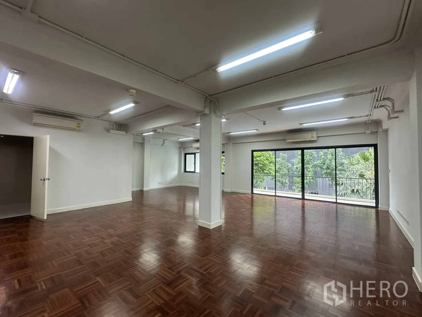 办公室 for rent in Watthana, Bangkok - 宽敞办公区，多个分体空调与立柱，大窗可见绿景。