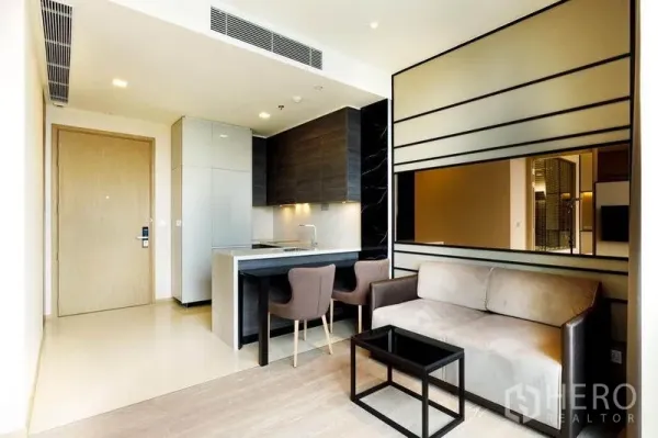 公寓 出租或出售在Watthana, Bangkok - 开放式客厅与小厨房，双人餐位与沙发，现代公寓。
