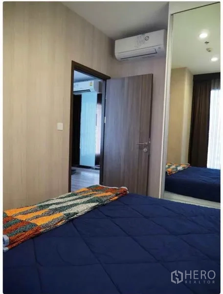 คอนโด ให้เช่าในHuai Khwang, Bangkok - ห้องนอนที่สองมีเครื่องปรับอากาศ ชุดเครื่องนอนสีน้ำเงิน และตู้เสื้อผ้าบานกระจกเต็มสูง