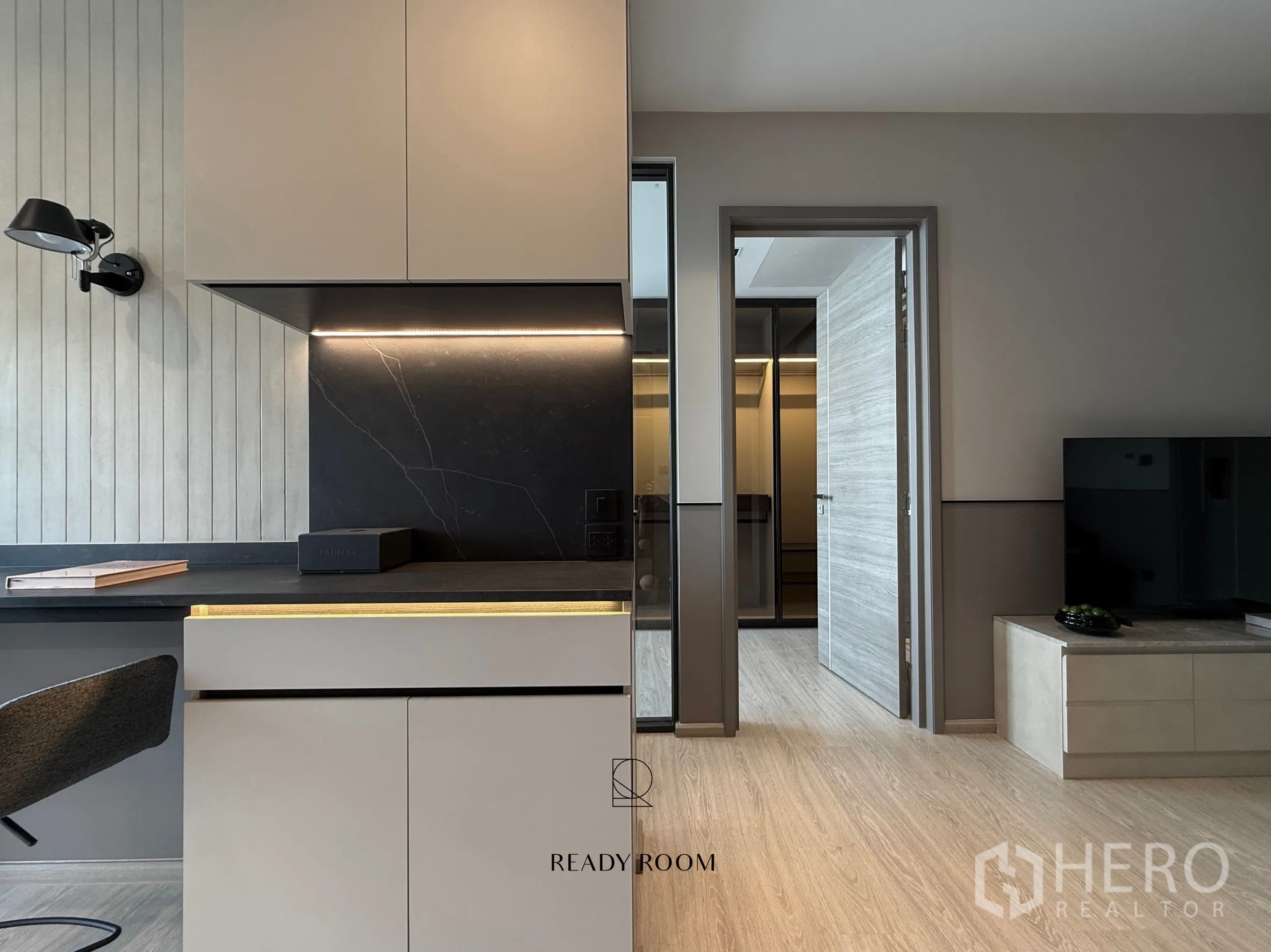 คอนโด for rent in Khlong Toei, Bangkok - ภาพระยะใกล้ของครัวมินิมอลผนังกันเปื้อนสีเข้มและโถงไปยังตู้เสื้อผ้า.