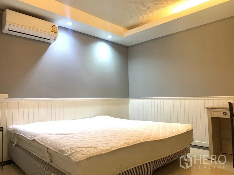 Condominium for rent in Khlong Toei, Bangkok - Second bedroom with queen bed, air conditioning and warm recessed lighting.