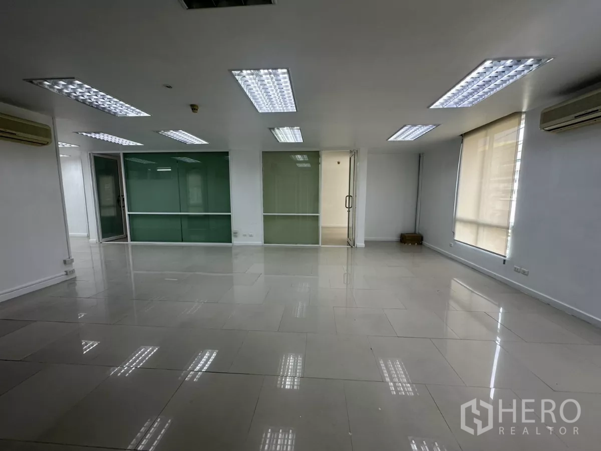 Office Space for rent in Huai Khwang, Bangkok - Spacious office area with roller-blind windows, ceiling grid lights and split air conditioners.