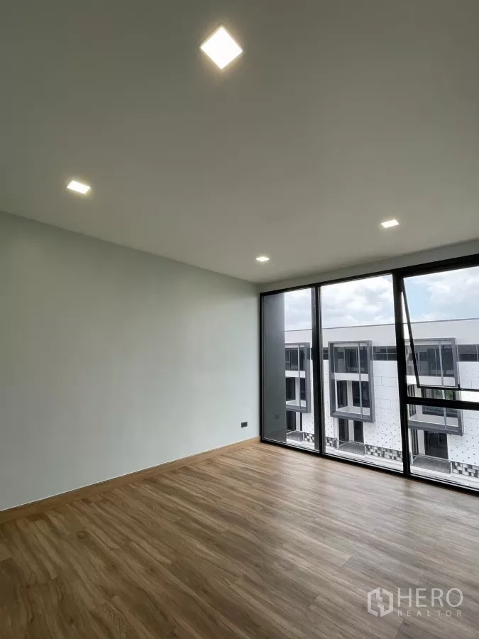 Home Office for rent in Khan Na Yao, Bangkok - Bedroom with floor-to-ceiling windows offering estate views and abundant natural light.