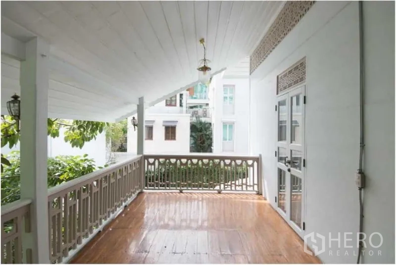 独立式住宅 出租在Bang Rak, Bangkok - 宽敞的覆顶露台，木地板与栏杆，可望邻近建筑。