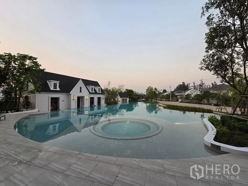 Detached House for rent in Bang Phli, Samut Prakan - Resort‑style communal swimming pool with clubhouse buildings and landscaped edges.