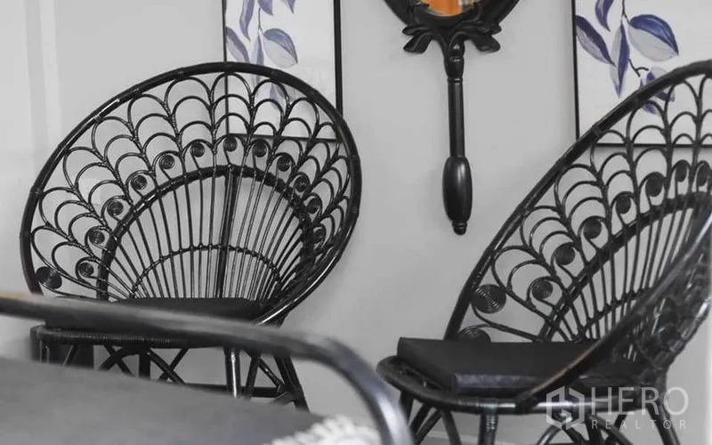 Townhouse for rent in Watthana, Bangkok - Two black rattan accent chairs against decorative wall art.