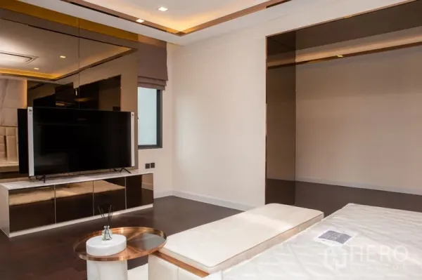 บ้าน ให้เช่าหรือขายในBangkok - มุมห้องนอนพร้อมทีวีติดผนัง ตู้กระจกเงา และไฟฝ้าซ่อน