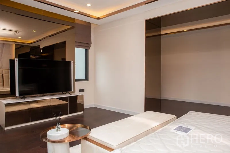 บ้าน ให้เช่าหรือขายในBangkok - มุมห้องนอนพร้อมทีวีติดผนัง ตู้กระจกเงา และไฟฝ้าซ่อน