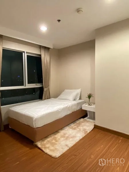 คอนโด ให้เช่า - ห้องนอนมุมห้อง เตียงเดี่ยว โต๊ะข้างเตียง และหน้าต่างสูง