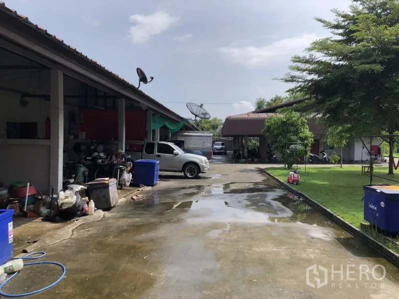 บ้าน ขายในLam Luk Ka, Pathum Thani - ด้านข้างอาคารบริการ พื้นที่จอดรถและสนามหญ้าเขียว