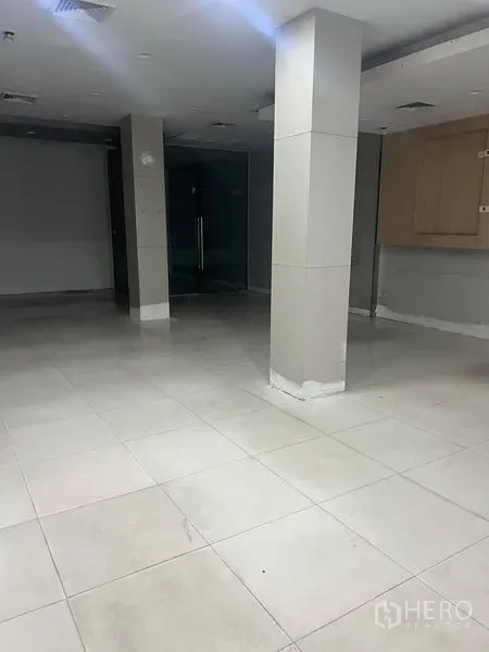 店屋 出租在Samphanthawong, Bangkok - 一层铺有瓷砖的商业大厅，方形立柱与玻璃门。