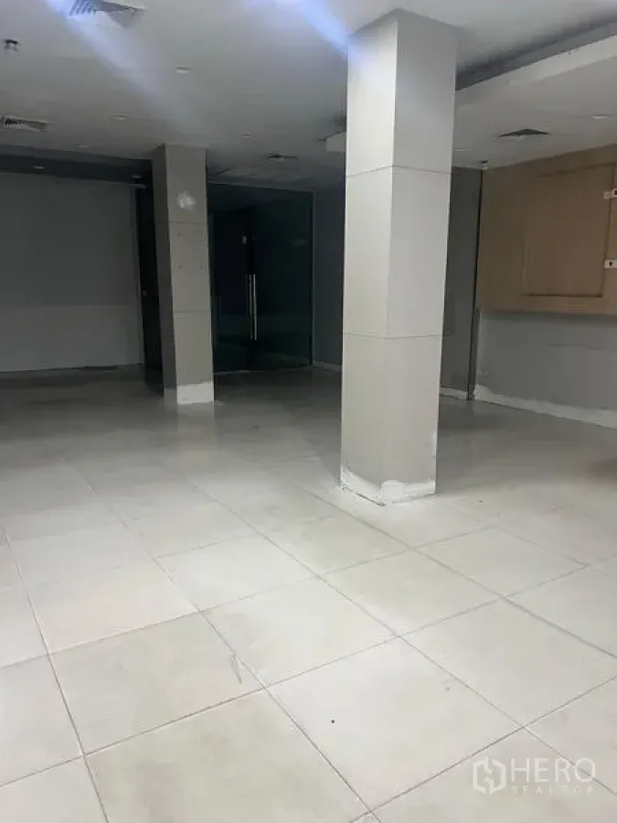 店屋 出租在Samphanthawong, Bangkok - 一层铺有瓷砖的商业大厅，方形立柱与玻璃门。