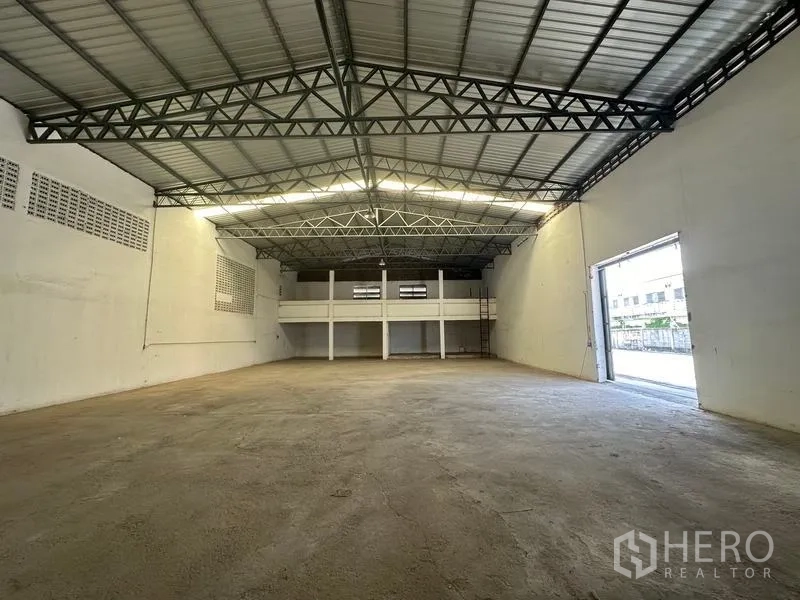 Warehouse for rent in Mueang Pathum Thani, Pathum Thani - Warehouse hall looking toward the loading door with ample natural light and broad working area.