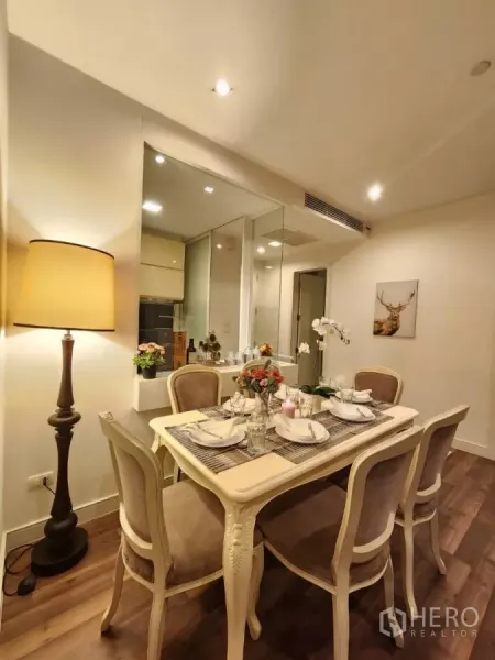 Condominium for rent in Phra Khanong, Bangkok - Cozy six-seat dining area with warm lighting beside a glass partition to the kitchen.