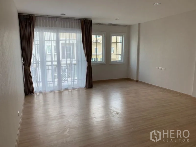 联排别墅 出租在Bang Na, Bangkok - 宽敞卧室，木地板，带阳台门与转角窗帘