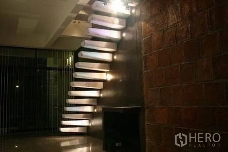 Detached House for rent in Wang Thonglang, Bangkok - Floating staircase with step lighting against a dark feature wall.