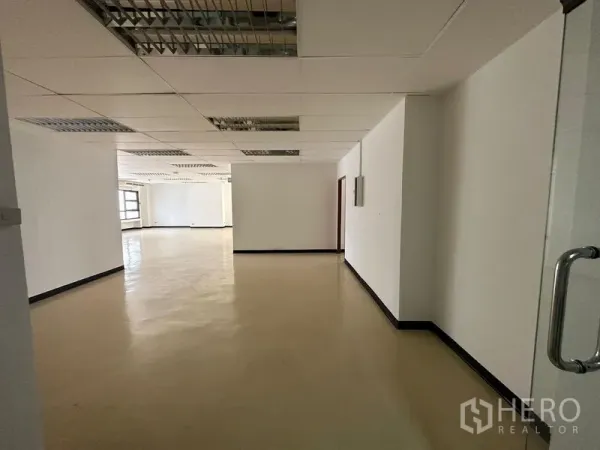 Office Space for rent in Pathum Wan, Bangkok - Entrance corridor opening to a large office floor with suspended ceiling and neutral floors.