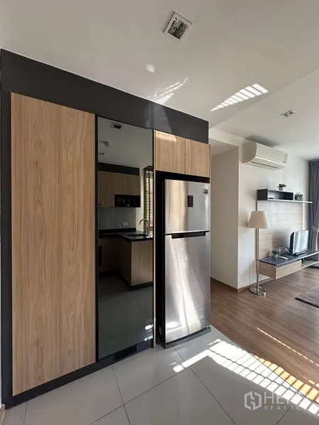 Condominium for rent in Watthana, Bangkok - Compact kitchen with black stone countertops, sink, built-in oven, dining set, and wooden blinds.
