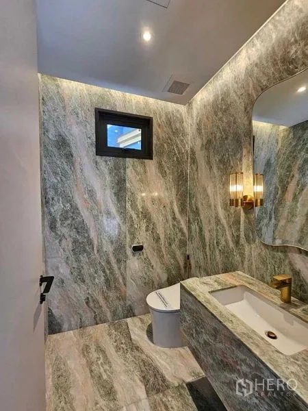 Detached House for rent in Wang Thonglang, Bangkok - Powder room clad in green marble with illuminated mirror and basin.