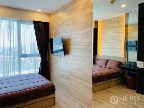 Condominium for rent in Bang Na, Bangkok - Two adjacent bedrooms with wood-tone walls, large windows and a wall-mounted TV.