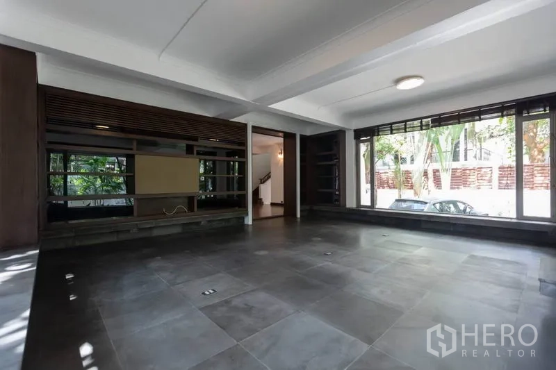 独立式住宅 出租在Pathum Wan, Bangkok - 多功能房，石板地面与宽幅落地窗面向车道。