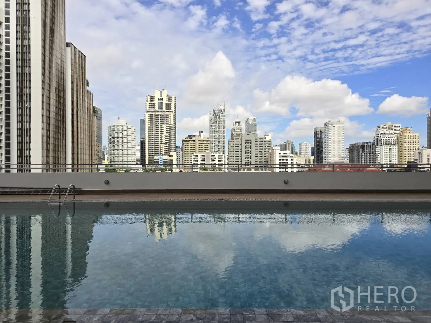 ออฟฟิศ for rent in Watthana, Bangkok - สระว่ายน้ำกลางแจ้งพร้อมวิวตึกสูงของกรุงเทพฯ ใต้ท้องฟ้าสีฟ้า.
