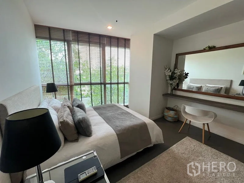Condominium for sale in Khlong San, Bangkok - Bedroom with dressing corner, wall-length mirror, and soft natural light.