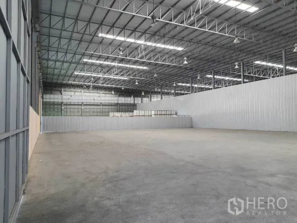 货栈 出租在Chachoengsao - 以金属波纹板分隔的开阔存储区，配备LED高棚灯。
