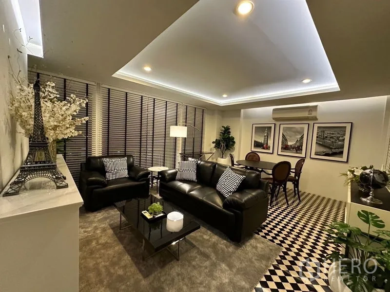 Detached House for rent - Stylish lounge with black leather sofas, checkerboard flooring and a dining nook.