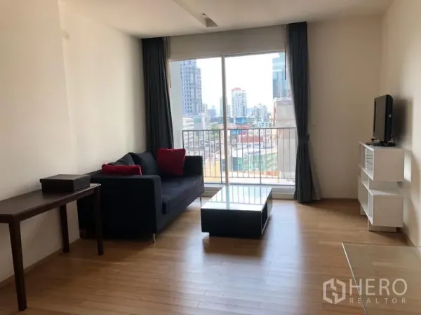 Condominium for rent in Khlong Toei, Bangkok - Bright living room at Siri at Sukhumvit with sofa, coffee table, TV stand and balcony showcasing a city view near Thonglor.