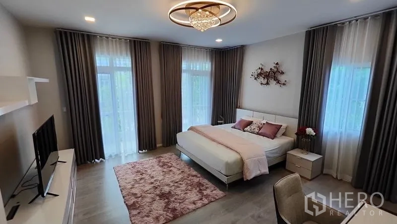 Detached House for rent in Prawet, Bangkok - Spacious master bedroom with chandelier, large windows and soft pink accents.