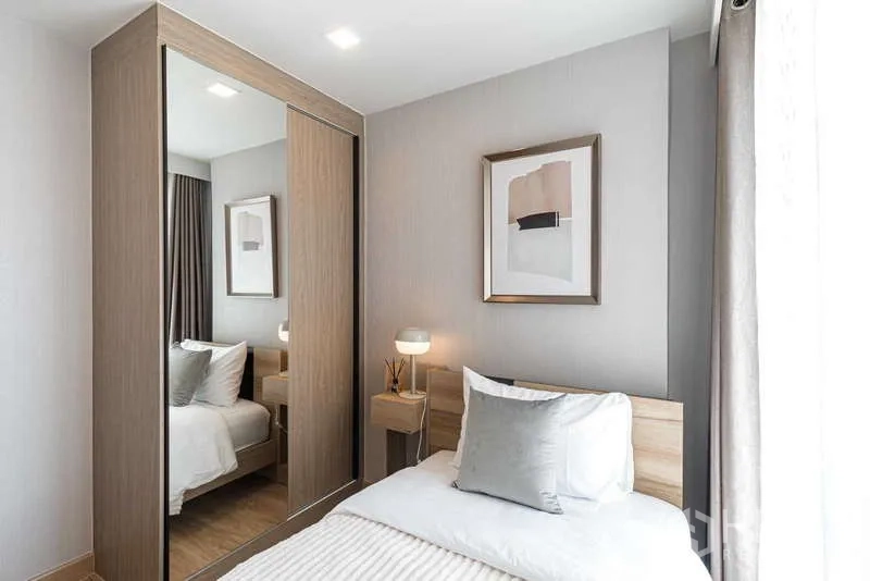 Condominium for rent - Compact bedroom with sliding mirrored wardrobe and large window.