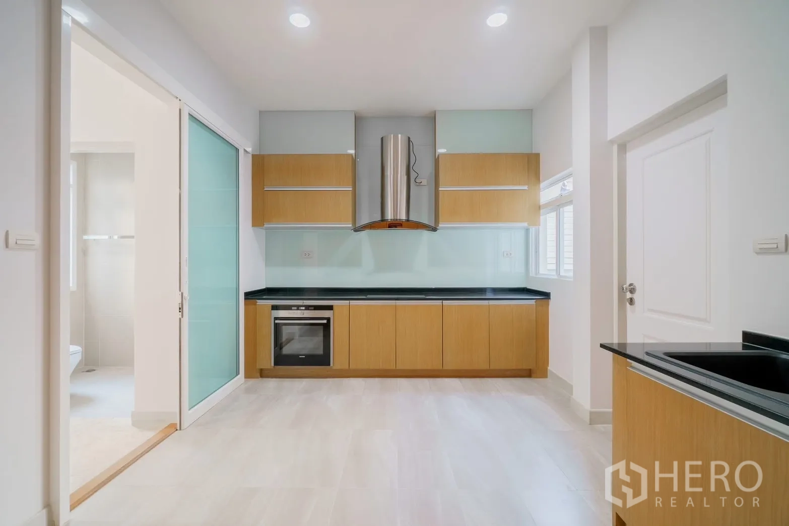 独栋房屋 for rent or sale in Saphan Sung, Bangkok - 现代厨房，烤箱、油烟机与木质橱柜。