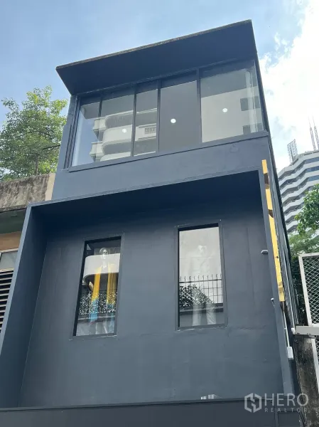 Retail Space for rent in Khlong Toei, Bangkok - Front elevation of modern two-storey retail unit with large upper glass windows under blue sky.
