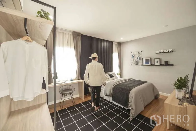 Detached House for sale in Lam Luk Ka, Pathum Thani - Cozy secondary bedroom with large windows, study desk and wardrobes.