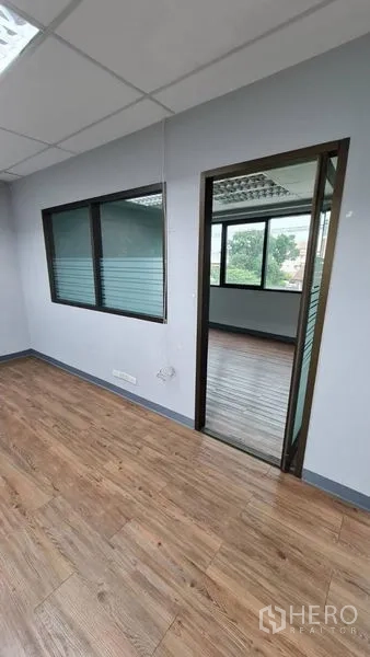 办公空间 出租在Watthana, Bangkok - 内部走廊，带窗式隔断与通往相邻房间的门。