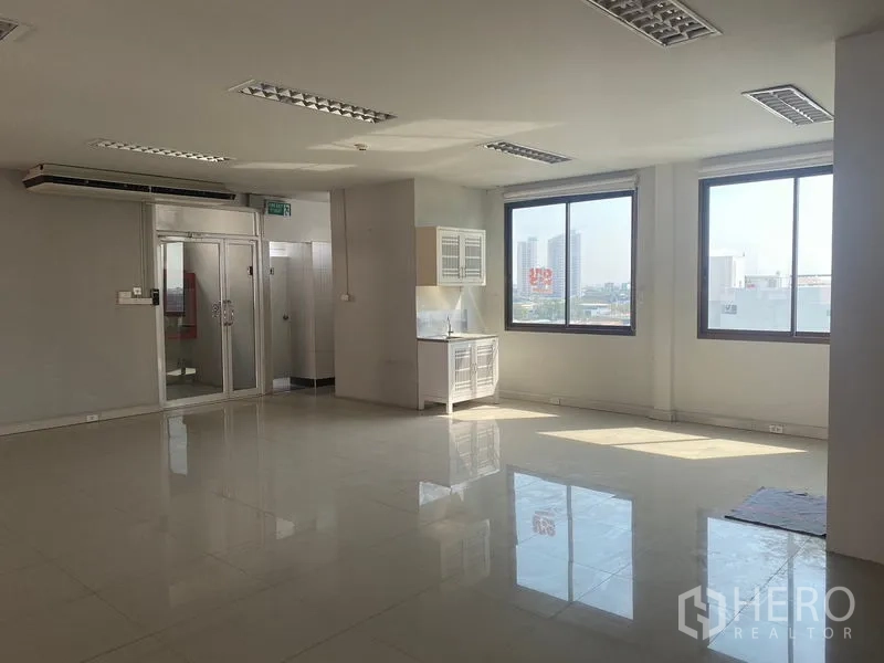 Office Space for rent in Bang Na, Bangkok - Corner office area featuring a compact pantry with sink, large windows and glass door.