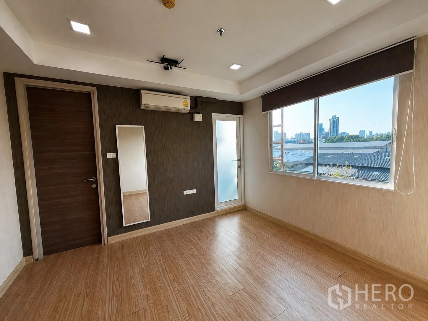家庭办公室 for rent or sale in Yan Nawa, Bangkok - 楼上房间带大窗与城市景观，并有小阳台门。