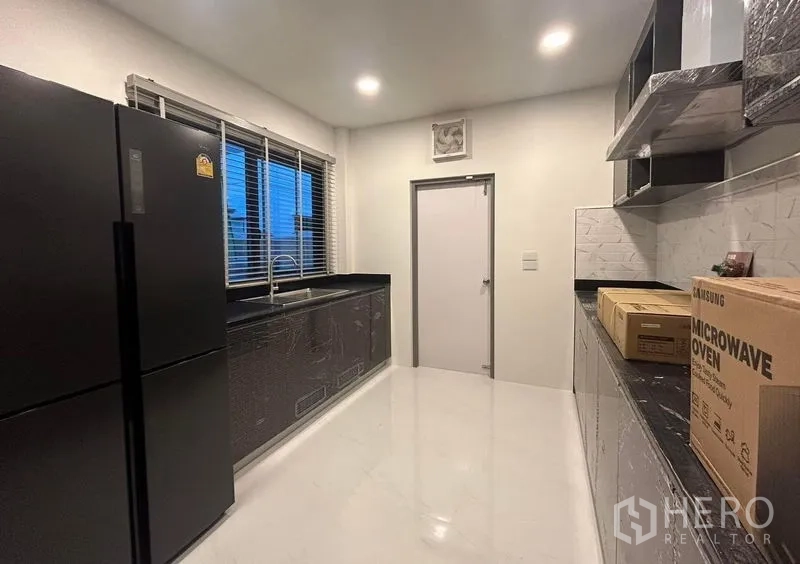 Detached House for rent - Closed kitchen with black stone countertops, window and new appliances.