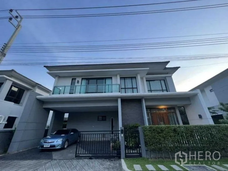 独立式住宅 出租在Mueang Nonthaburi, Nonthaburi - 两层独栋别墅外观，带电动门车棚与阳台。