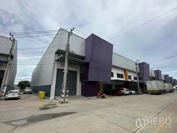 Factory for rent in Bang Phli, Samut Prakan - Modern mini factory row with purple facade, roller shutter loading bay and a wide internal road in Bang Phli.