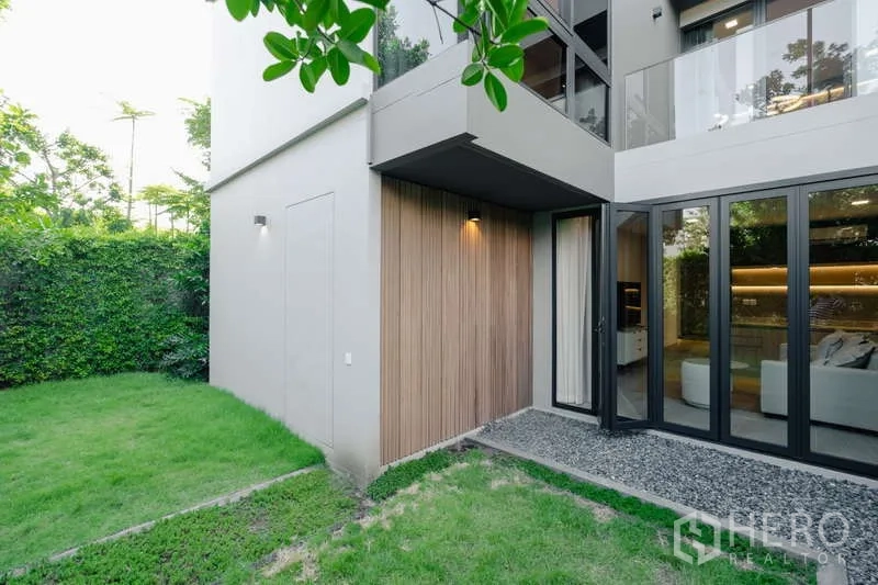 Detached House for rent in Saphan Sung, Bangkok - Modern exterior corner with glass doors and green lawn.
