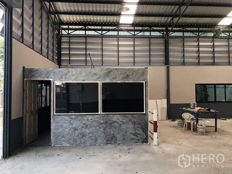 货栈 出售在Pathum Thani - 仓库内独立办公室盒体，带大窗，旁有工作台与装卸区域。
