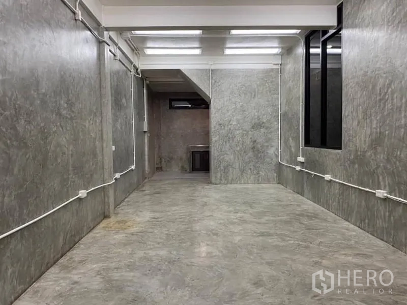 办公空间 出租在Yan Nawa, Bangkok - 狭长工作区，水泥地面，明管布线，高天花与侧窗。