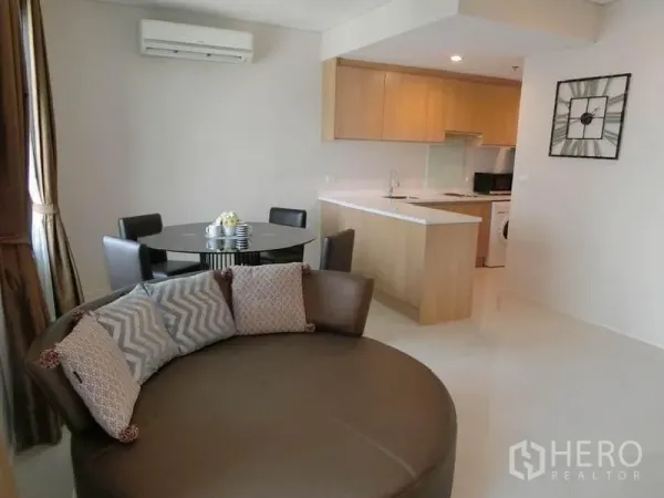 公寓 出租在Ratchathewi, Bangkok - 开放式客餐厅，圆形躺椅、餐桌，与浅木色厨房相连