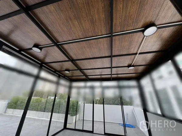 Retail Space for rent in Watthana, Bangkok - Close-up of wood-look ceiling with recessed lights inside the glass showroom.