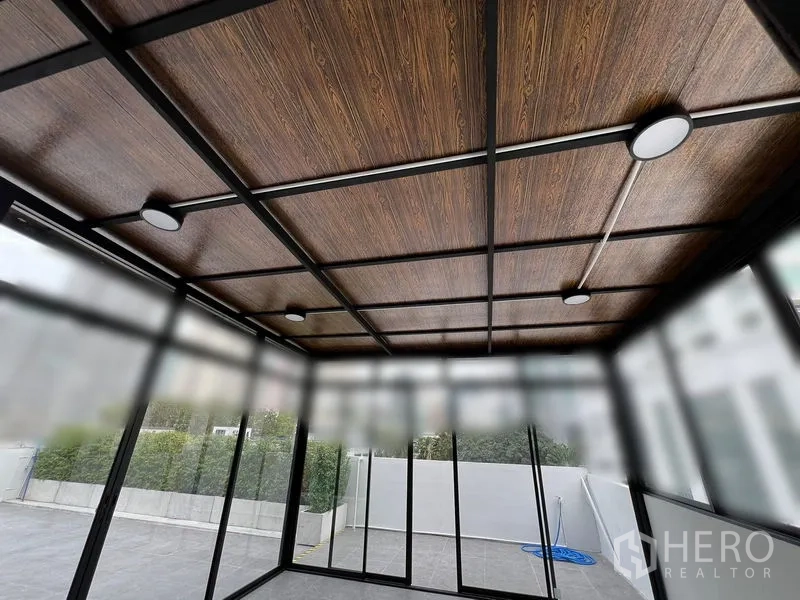 Retail Space for rent in Watthana, Bangkok - Close-up of wood-look ceiling with recessed lights inside the glass showroom.