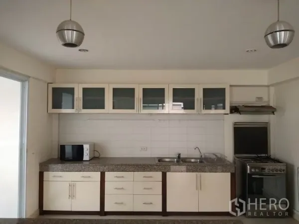 独立式住宅 出租在Watthana, Bangkok - 明亮整体厨房，白色橱柜、花岗岩台面、双水槽与燃气灶