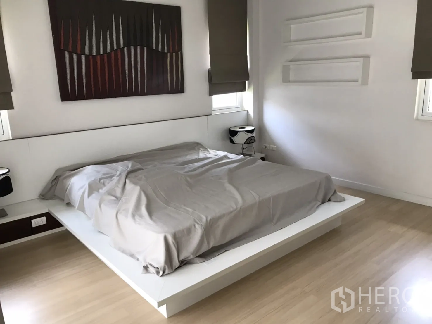 Detached House for rent or sale in Saphan Sung, Bangkok - Master bedroom featuring a platform bed, wood floors and contemporary artwork.