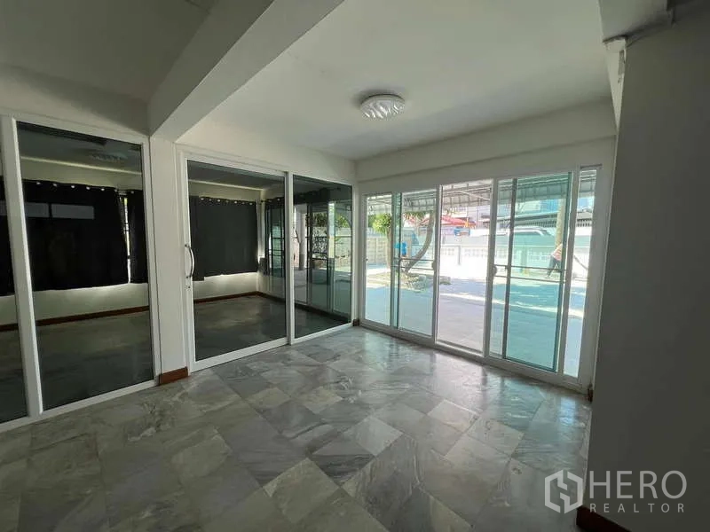 บ้าน ให้เช่าในBang Na, Bangkok - ห้องกระจกชั้นล่าง ประตูบานเลื่อน พื้นกระเบื้อง มองออกสู่ลานบ้าน